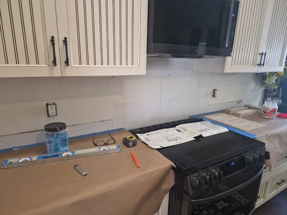 Kitchen backsplash installation in progress around the range