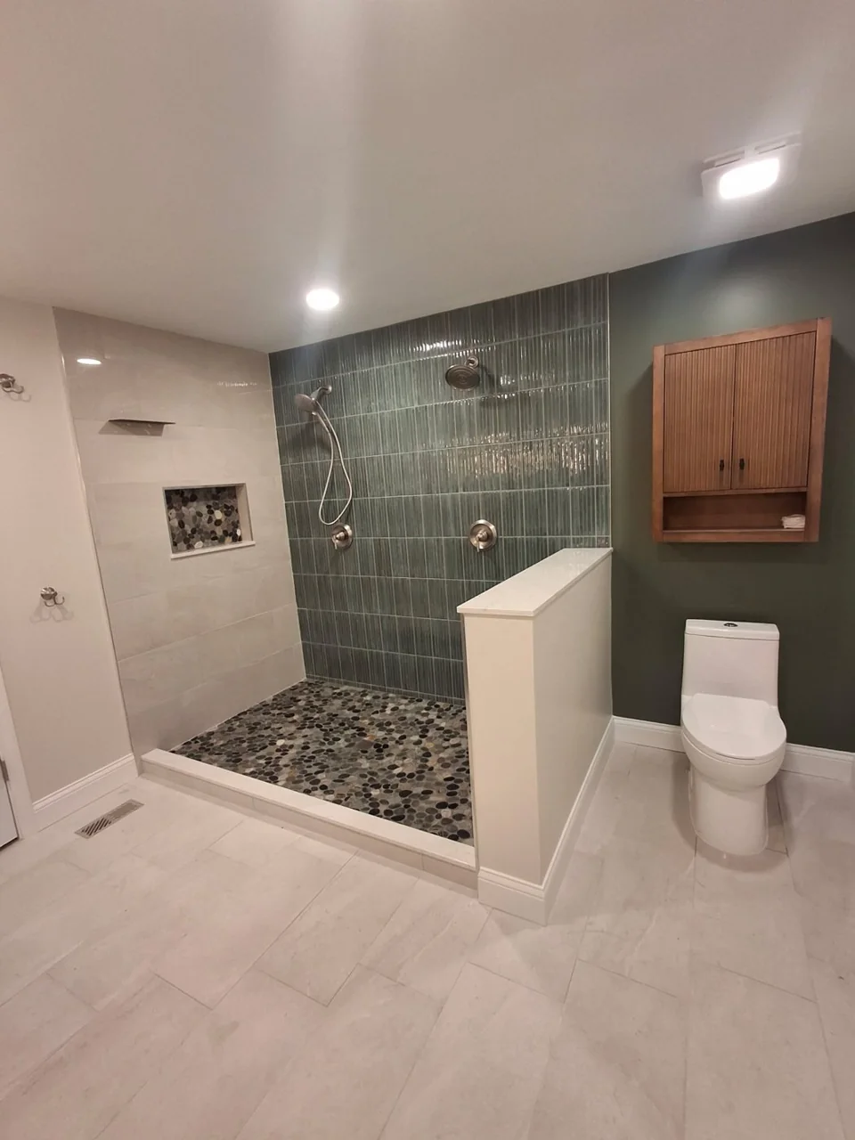 Completed bathroom with a tiled shower, toilet and vanity