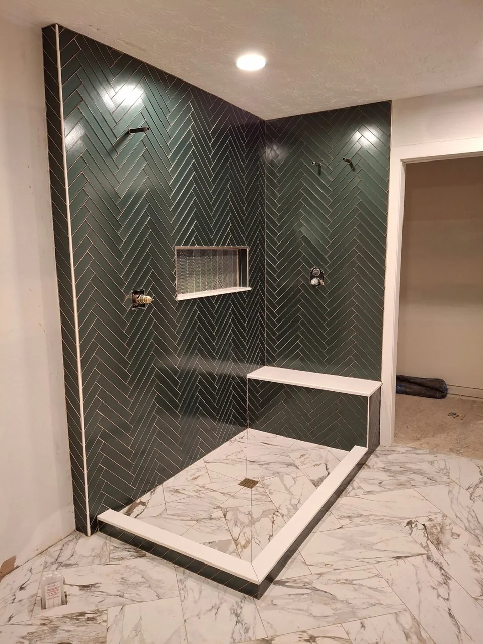 Dark tile shower enclosed by glass panels