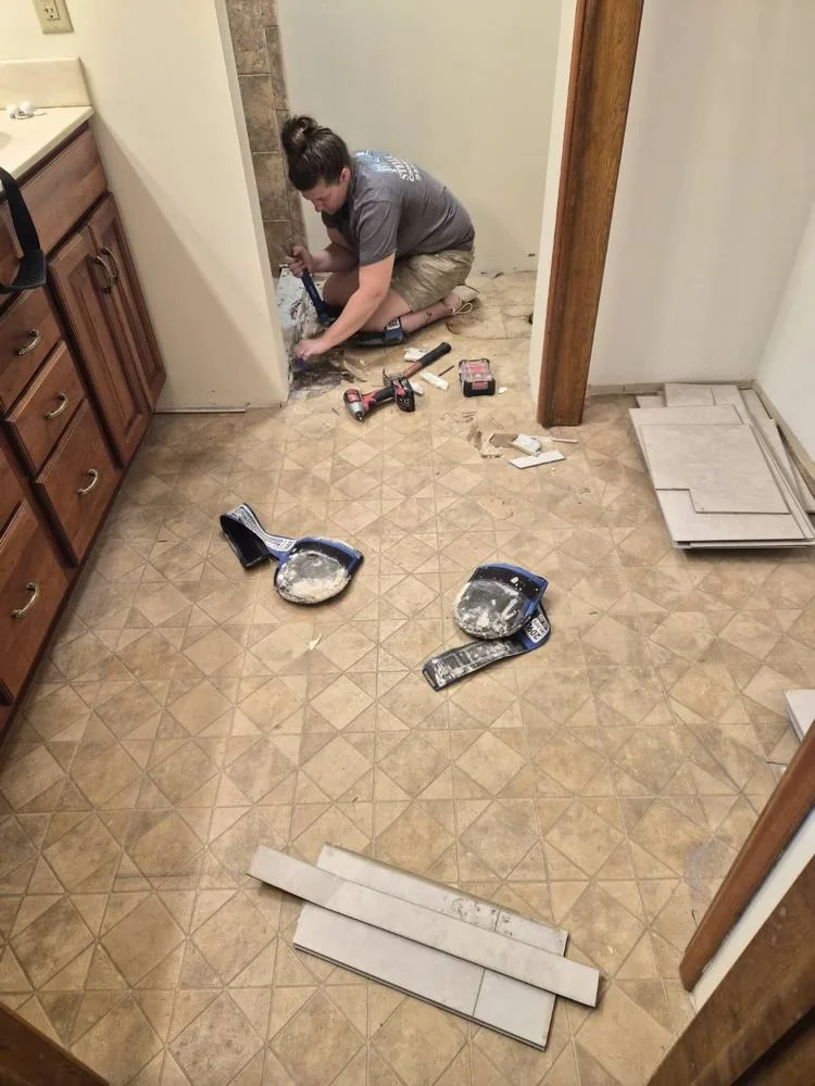 Tile flooring being installed around a bathroom doorway