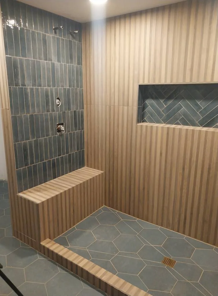 Vertical wall tile shower with a built-in bench and recessed niche